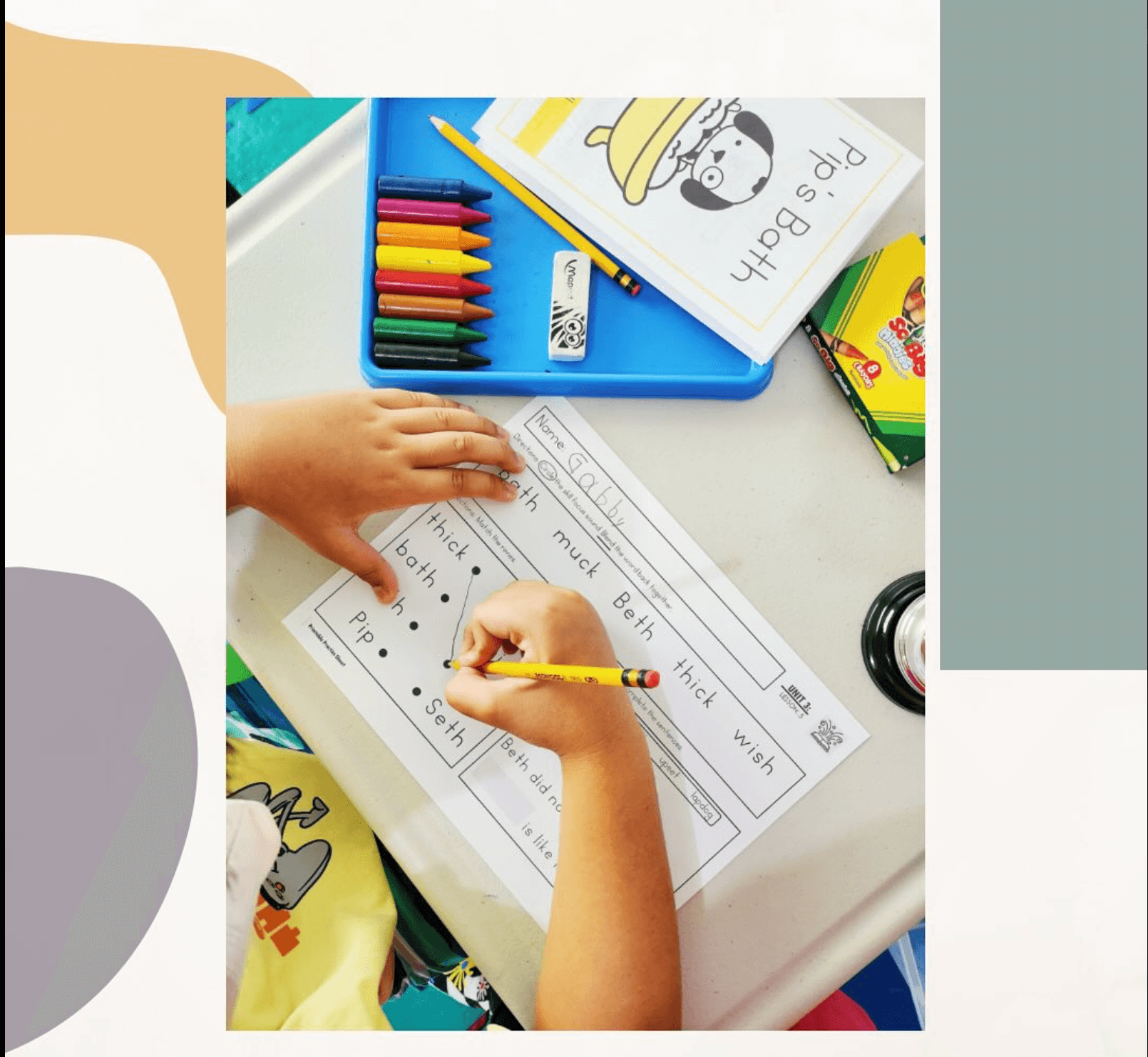 Child writing on a worksheet with crayons