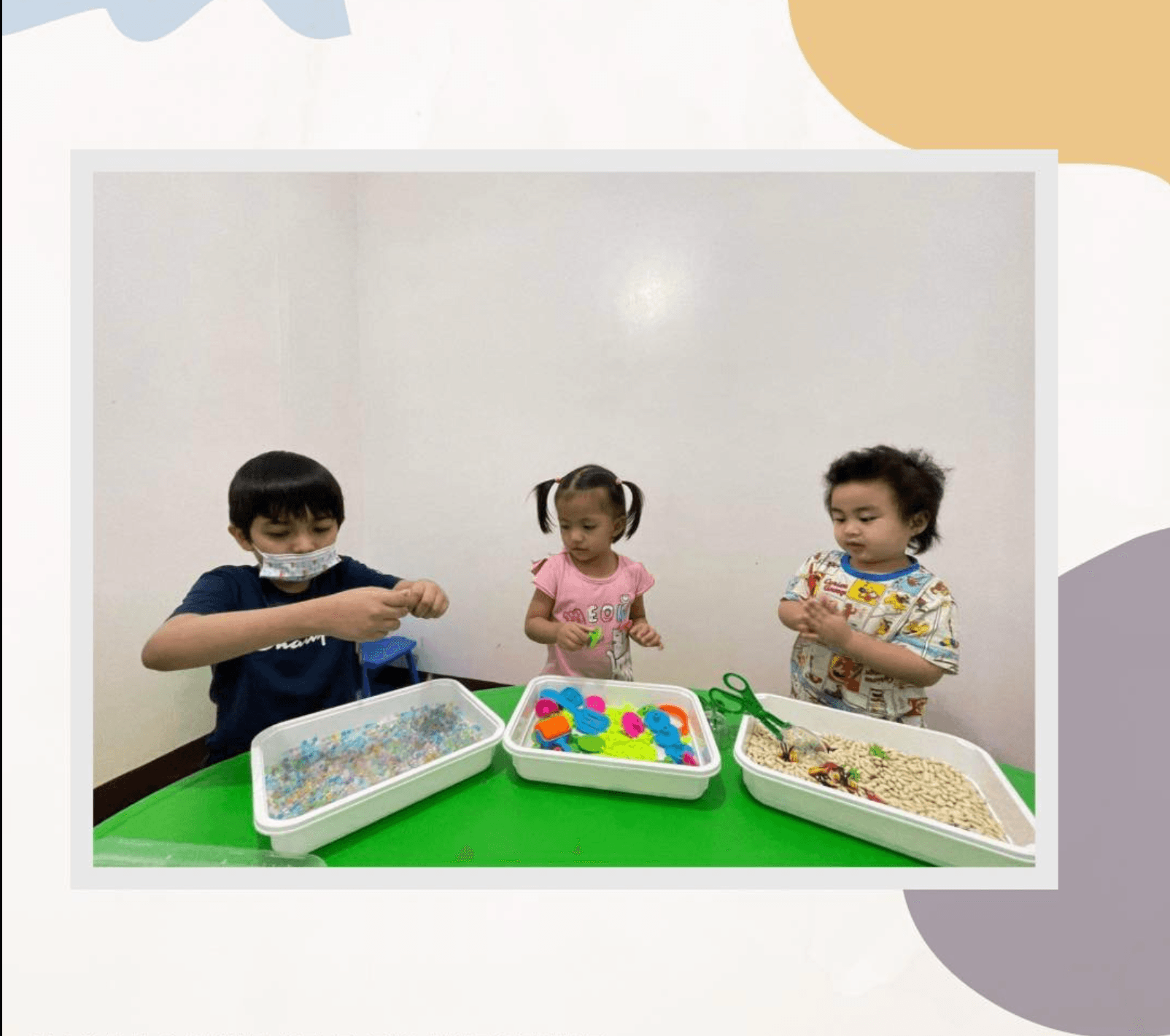 Three kids playing with a sensory bin